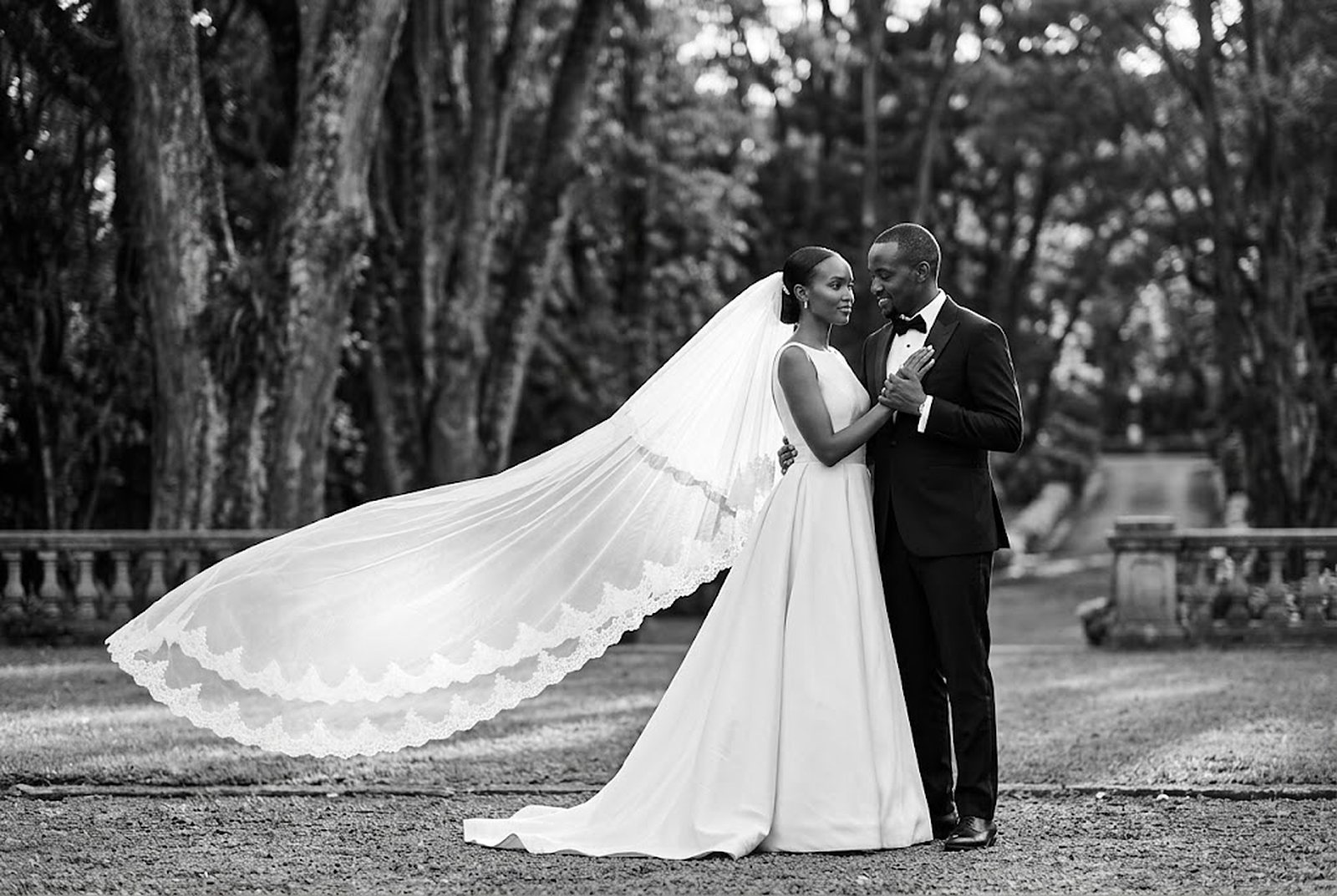 Black and white wedding portrait, bride's veil caught by the wind